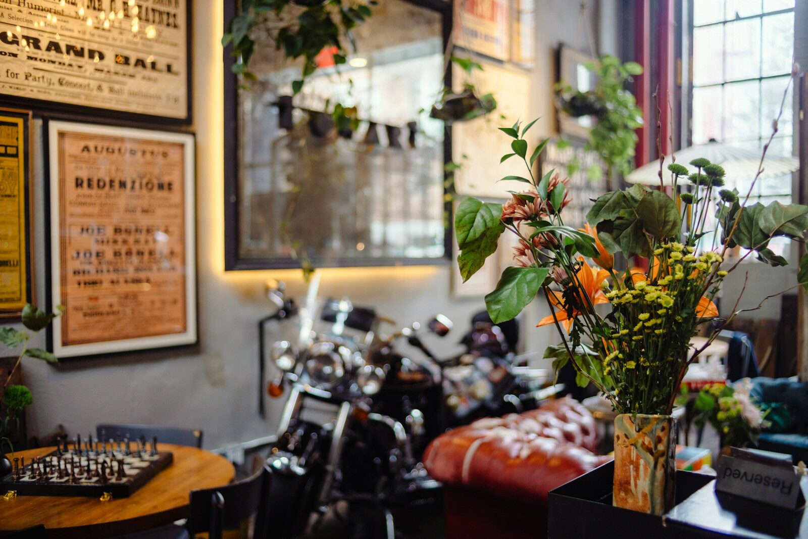 Motorcycle and flowers in a room with posters.